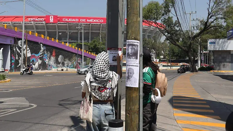 Con un ajolote y una pala “mundialista” familias pegan fichas de búsqueda cerca del Estadio Azteca